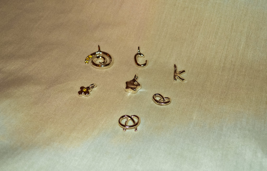 Silver jewelry pieces on a beige fabric background