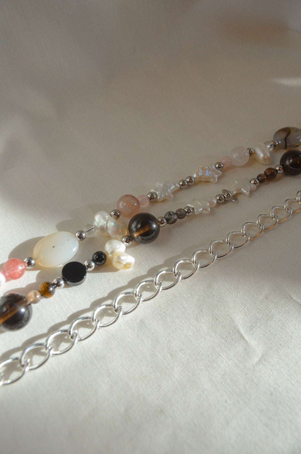 Necklace with multicolored beads and silver chain on a white background