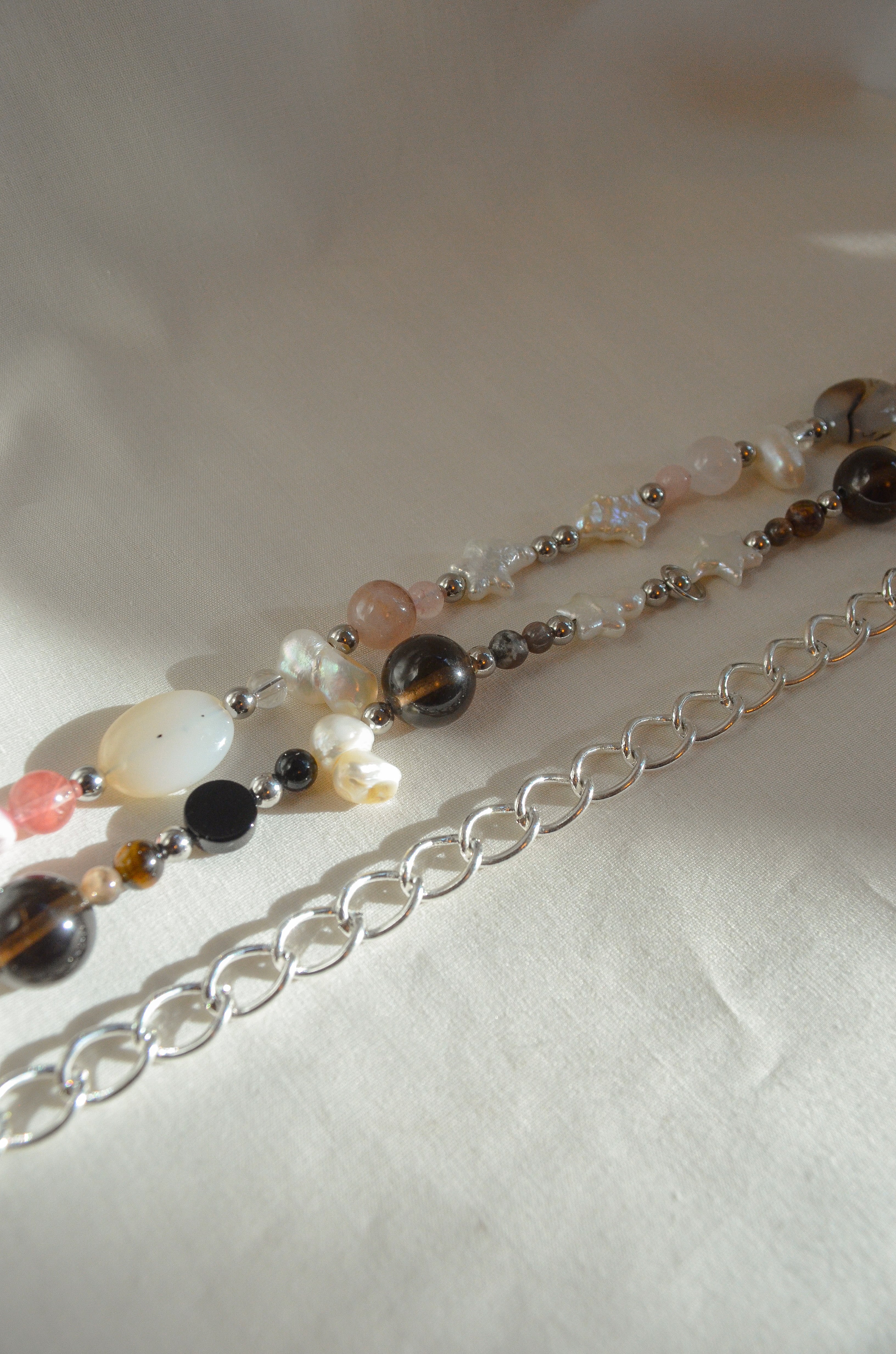 Necklace with multicolored beads and silver chain on a white background